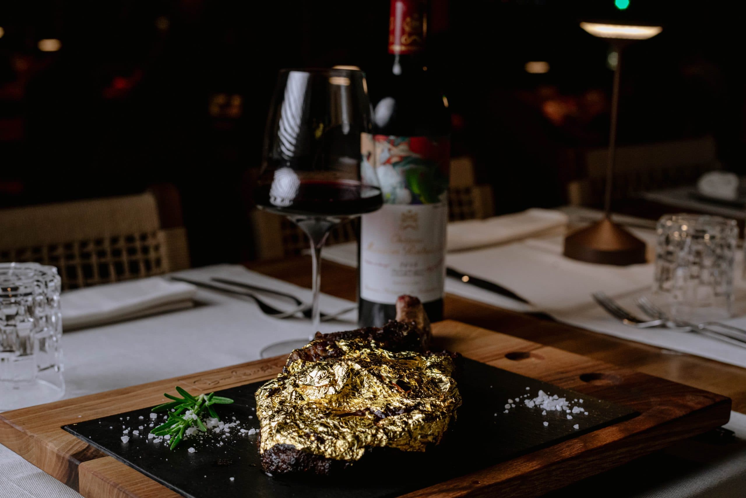 Golden Tomahawk steak in edible gold leaf, with red wine