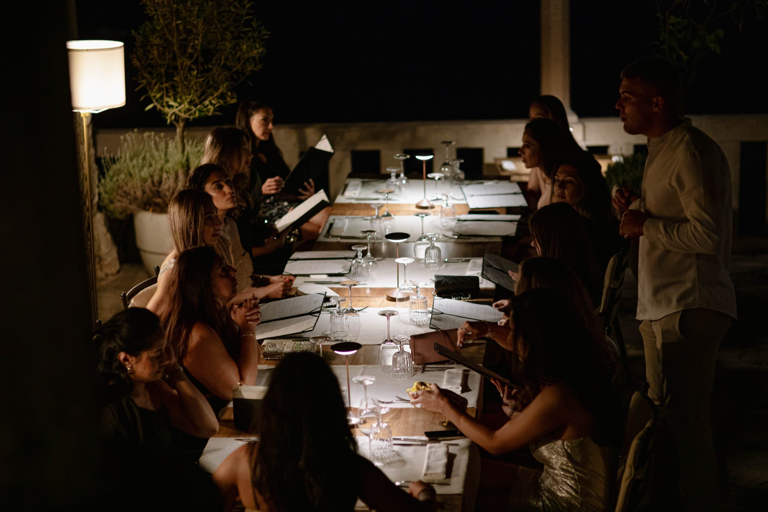 A long candle-lit table at a private dinner on the terrace