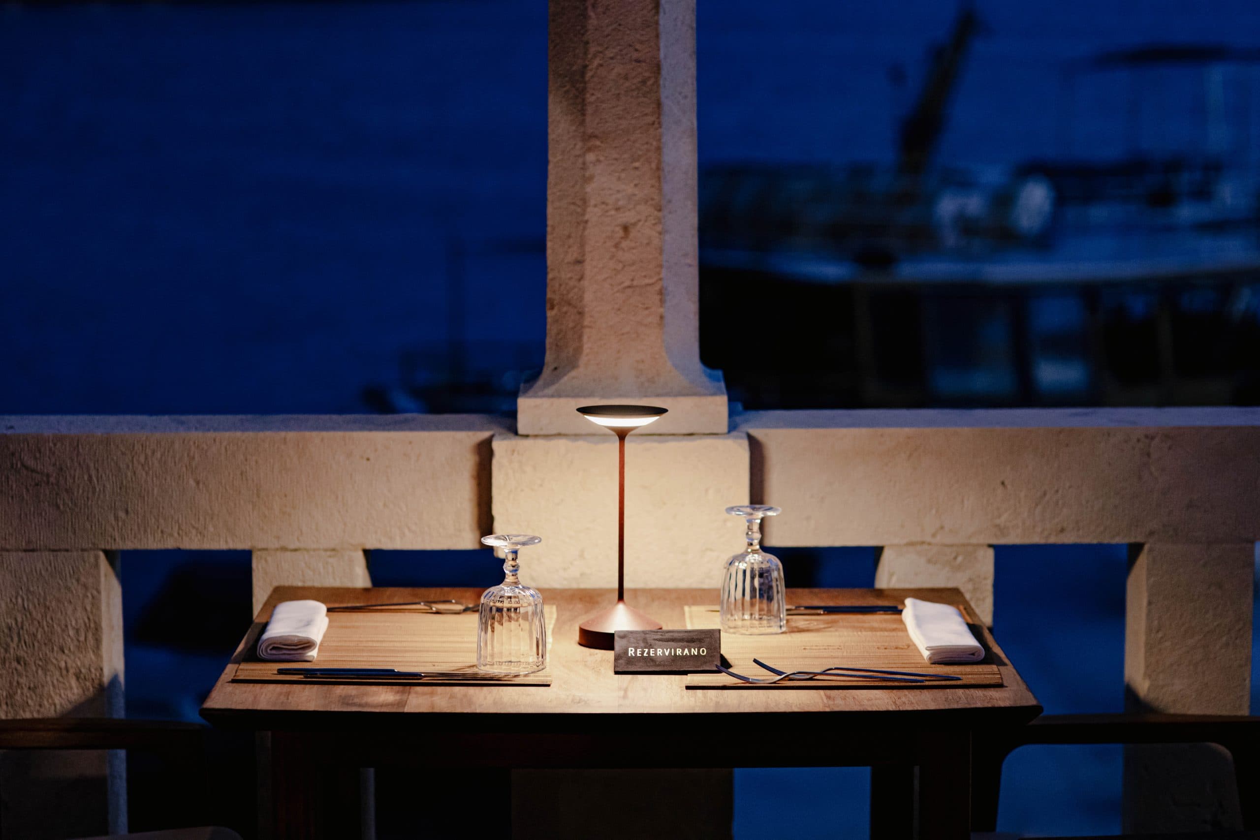 A reserved table for two at blue hour, lamp lit